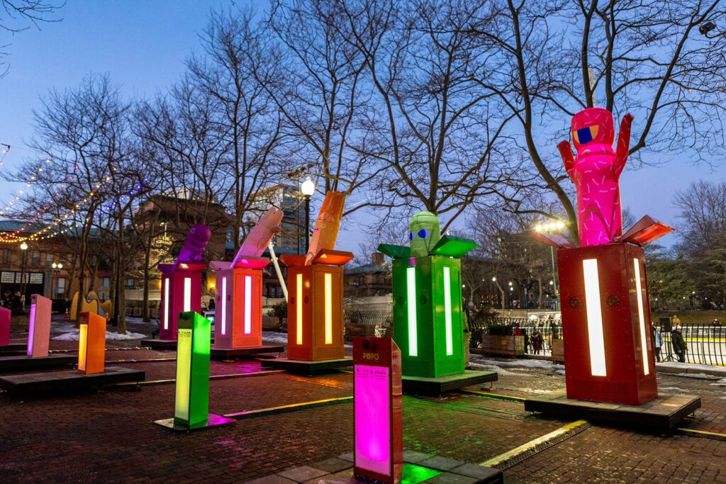 Colorful 'POP!' installation by Gentilhomme at LUMINA, featuring vibrant illuminated sculptures in a park setting at dusk.