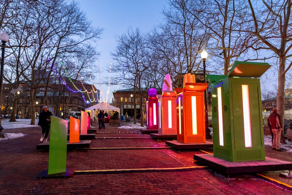 Colorful interactive installations by Gentilhomme at LUMINA, with vibrant lights and people enjoying the evening.