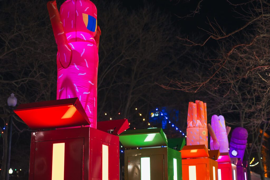 POP! from Gentilhomme at LUMINA features colorful, illuminated inflatable figures on vibrant pedestals at night.