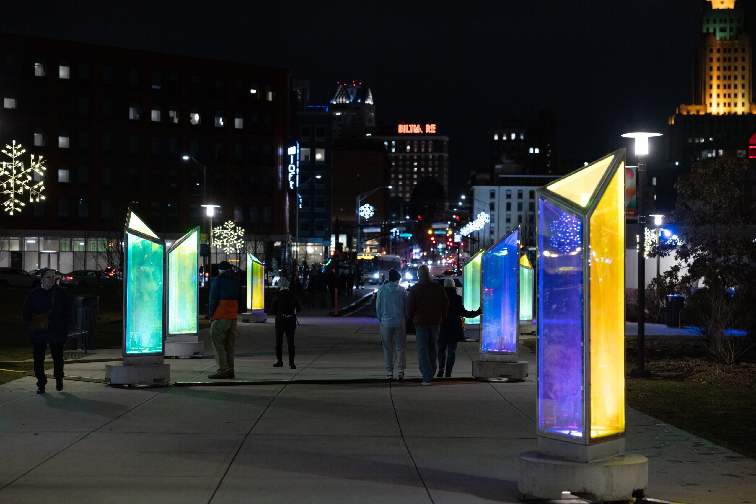 Downtown Providence illuminated walkway featuring vibrant, colorful art installations during the LUMINA event, highlighting a modern urban winter nightscape.