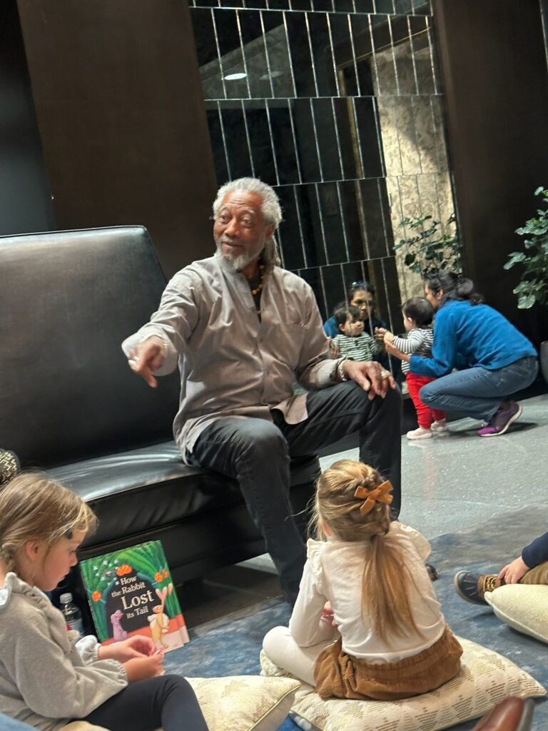 Len Cabral, master storyteller, sharing tales with an attentive group of children, captivating their imagination and hearts.